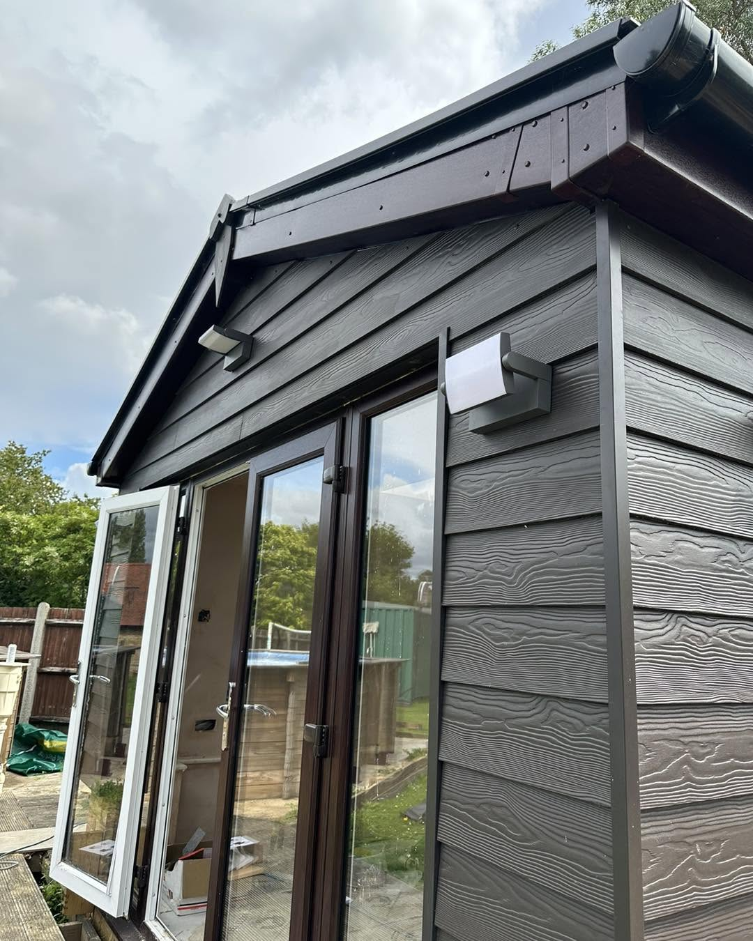 Garden room exterior with modern black up-and-down wall lights installed by a Maidstone electrician